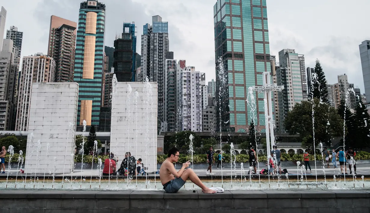 Seorang pria duduk di sebelah air mancur di Taman Peringatan Sun Yat Sen di Hong Kong (21/4/2020). Hong Kong melaporkan penurunan kasus infeksi harian Covid-19, tetapi pemerintah kota mengatakan mereka tidak mengambil risiko apa pun. (AFP/Anthony Wallace)