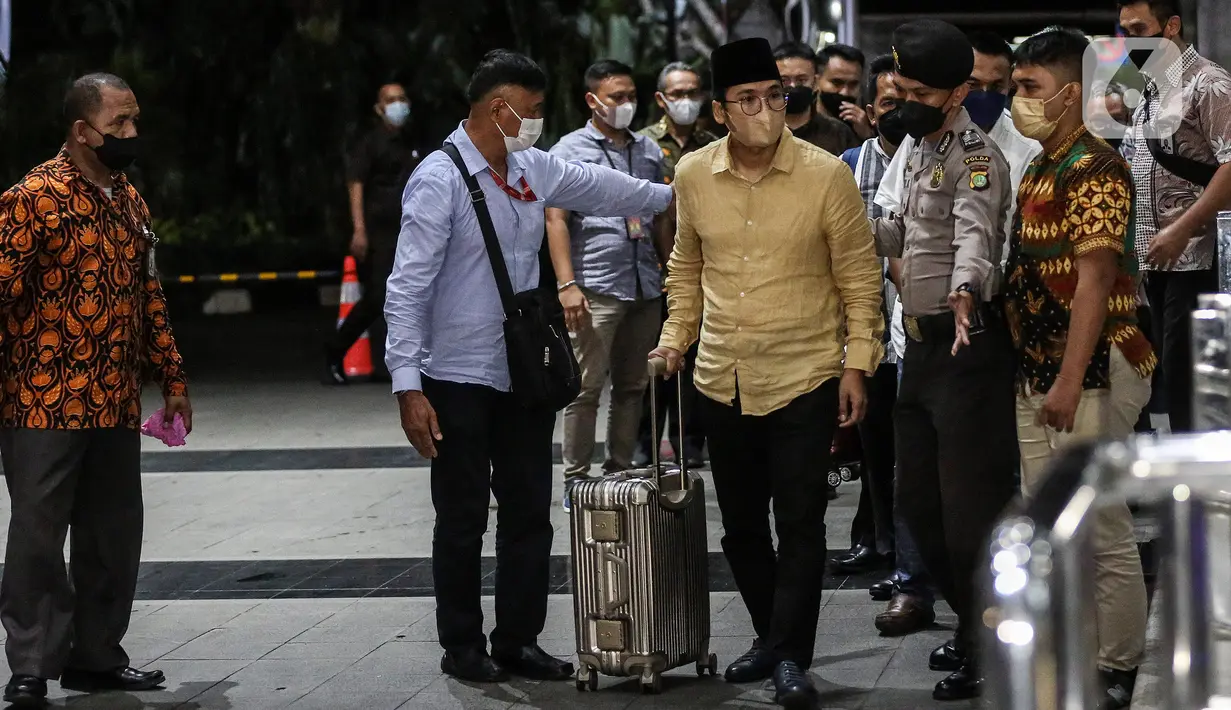 Bupati Bangkalan Abdul Latif Amin Imron membawa koper dan dikawal saat tiba di Gedung Komisi Pemberantasan Korupsi (KPK), Jakarta, Rabu (7/12/2022). KPK menangkap Bupati Bangkalan Abdul Latif Amin Imron sebagai tersangka kasus suap lelang jabatan di Pemerintahan Kabupaten Bangkalan, Jawa Timur. Total kekayaan yang dimiliki Abdul Latif sebanyak Rp 9,9 miliar. (Liputan6.com/Johan Tallo)