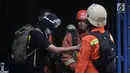 Petugas pemadam saat mengevakuasi salah seorang korban selamat (kaos hitam) dari lokasi kebakaran di Gedung Kemenhub, Jakarta, Minggu (8/7). Hingga saat ini petugas kepolisian masih menyelidiki penyebab kebakaran tersebut. (Merdeka.com/Iqbal S Nugroho)