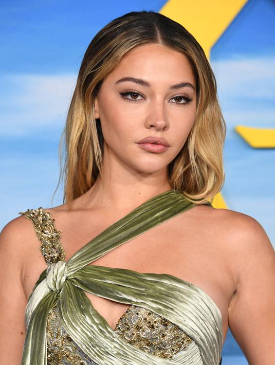 Madelyn Cline berpose saat menghadiri pemutaran perdana "Glass Onion: A Knives Out Mystery" di Academy Museum of Motion Pictures  di Los Angeles, California pada 14 November 2022. Ia melengkapi penampilannya dengan sepasang sandal bertali kaki terbuka berwarna nude. (Jon Kopaloff/Getty Images/AFP)