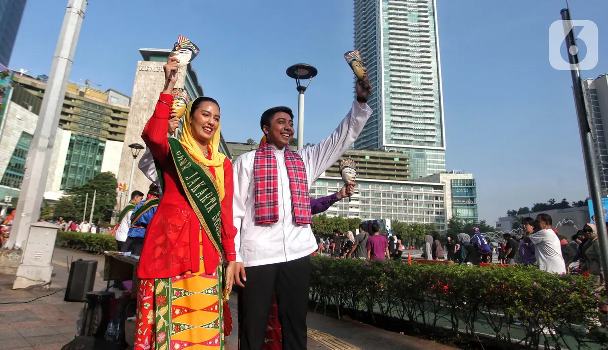 Abang None Jakarta melakukan tarian lenggang Jakarta saat sosialisasi pemilihan Abang None Jakarta 2025 di sekitar kawasan Bundaran Hotel Indonesia, Jakarta, Minggu (8/6/2025). (Liputan6.com/Angga Yuniar)