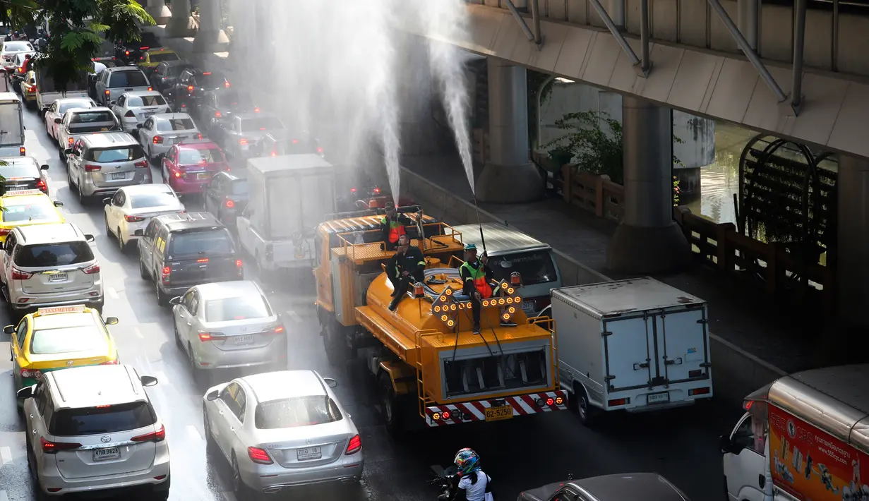 Petugas menyemprotkan air untuk mengurangi but asap tebal di Bangkok, Thailand (14/1). Tingkat kabut asap yang sangat tinggi diperburuk oleh pola cuaca yang meningkatkan kewaspadaan di seluruh Asia. (AP Photo/Sakchai Lalit)