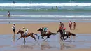 Para joki beraksi dalam kejuaraan tahunan pacuan kuda pantai di Loredo, Santander, Spanyol, (24/7/2016). (AFP/Cesar Manso)