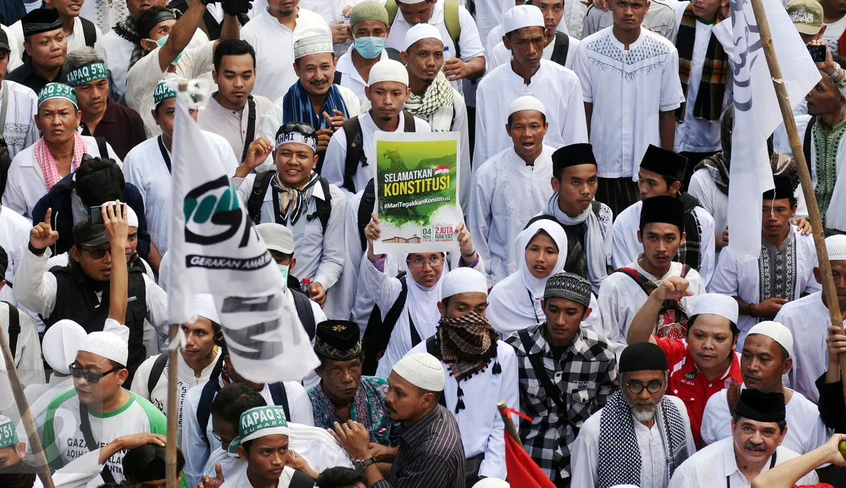 Ratusan ribu massa aksi damai membentangkan tulisan dan memenuhi ruas Jalan Merdeka Barat, Jakarta, Jumat (4/11). Massa melakukan aksi di depan Istana Negara menuntut penegakan hukum kasus dugaan penistaan agama. (Liputan6.com/Helmi Fithriansyah)