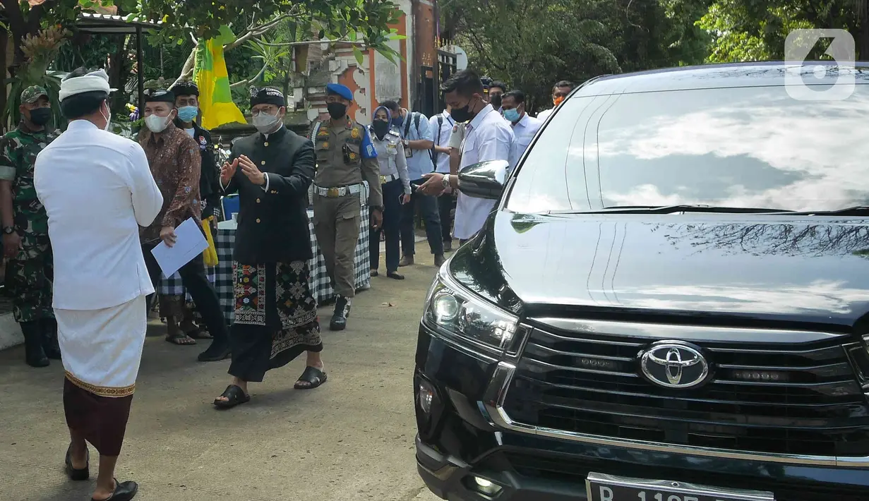 Gubernur DKI Jakarta, Anies Baswedan (baju hitam) tiba untuk menghadiri Upacara Tawur Agung Kesanga di Pura Aditya Jaya, Pulo Gadung, Rabu (2/3/2022). Anies yang mengenakan pakaian adat Bali dengan udeng hitam tersebut datang untuk menghormati umat Hindu di Jakarta. (Liputan6.com/Herman Zakharia)
