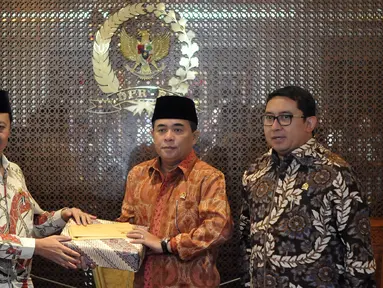 Pimpinan Komisi Yudisial (KY) Aidul Fitriciada Azhari memberikan cendera mata saat bertemu Ketua DPR Ade Komarudin (tengah) di Kompleks DPR, Senayan, Jakarta, Kamis (30/6). (Liputan6.com/Johan Tallo)