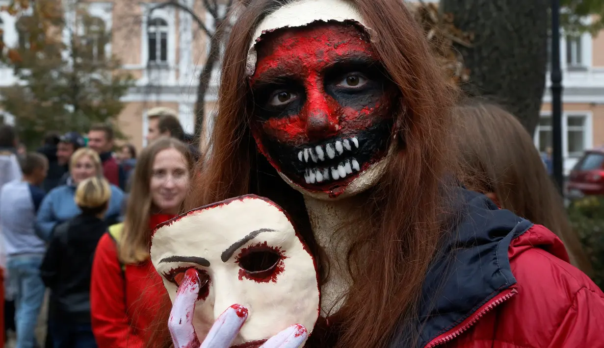 Seorang perempuan berpose dengan dandanan menyerupai zombie ketika berpartisipasi dalam 'Zombie Walk' di pusat Kota Kiev, Ukraina, 26 Oktober 2019. Menjelang perayaan Halloween pada 31 Oktober mendatang, warga di beberapa belahan dunia sudah mulai melakukan acara bertema horor. (AP/Efrem Lukatsky)