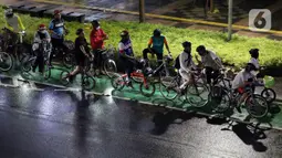 Pegiat bersepeda dan aktivis pecinta lingkungan jelang aksi gowes Kelap Kelip Jakarta Night Ride #NOP26, Jalan Jenderal Sudirman, Jakarta, Jumat (26/11/2021). Aksi ini mendorong pemimpin dunia berkomitmen meningkatkan tingkat bersepeda untuk mengurangi emisi karbon. (Liputan6.com/Helmi Fithriansyah)
