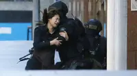 Seorang sandera berlari ke arah polisi setelah berhasil keluar dari Kafe Lindt, Martin Place, Sydney, Senin (15/12/2014). (REUTERS/Jason Reed)