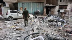 Seorang pria Palestina berdiri di tengah reruntuhan bangunan tempat tinggal dan mobil yang rusak setelah serangan Israel di Kota Gaza pada Kamis 4 Juni 2026. (Omar AL-QATTAA/AFP)