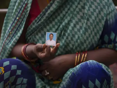 Savita Devi menunjukkan foto suaminya Manoj yang tubuhnya tidak dapat diidentifikasi setelah kecelakaan kereta api hari Jumat di Balasore, di rumah sakit All India Institute of Medical Sciences di Bhubaneswar, di negara bagian timur Odisha, India, Selasa (6/6/2023). (AP Photo/Rafiq Maqbool)