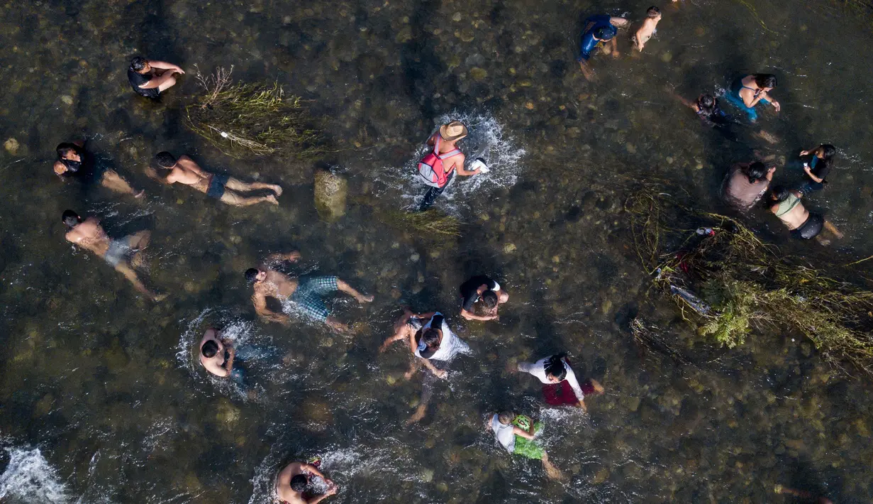 Imigran Honduras yang sedang menuju Amerika Serikat mandi di sungai di Pijijiapan, Meksiko, 25 Oktober 2018. Presiden Honduras, Juan Orlando Hernandez mengakui masalah sosial menjadi faktor utama gelombang imigran membeludak. (AP Photo/Rodrigo Abd)