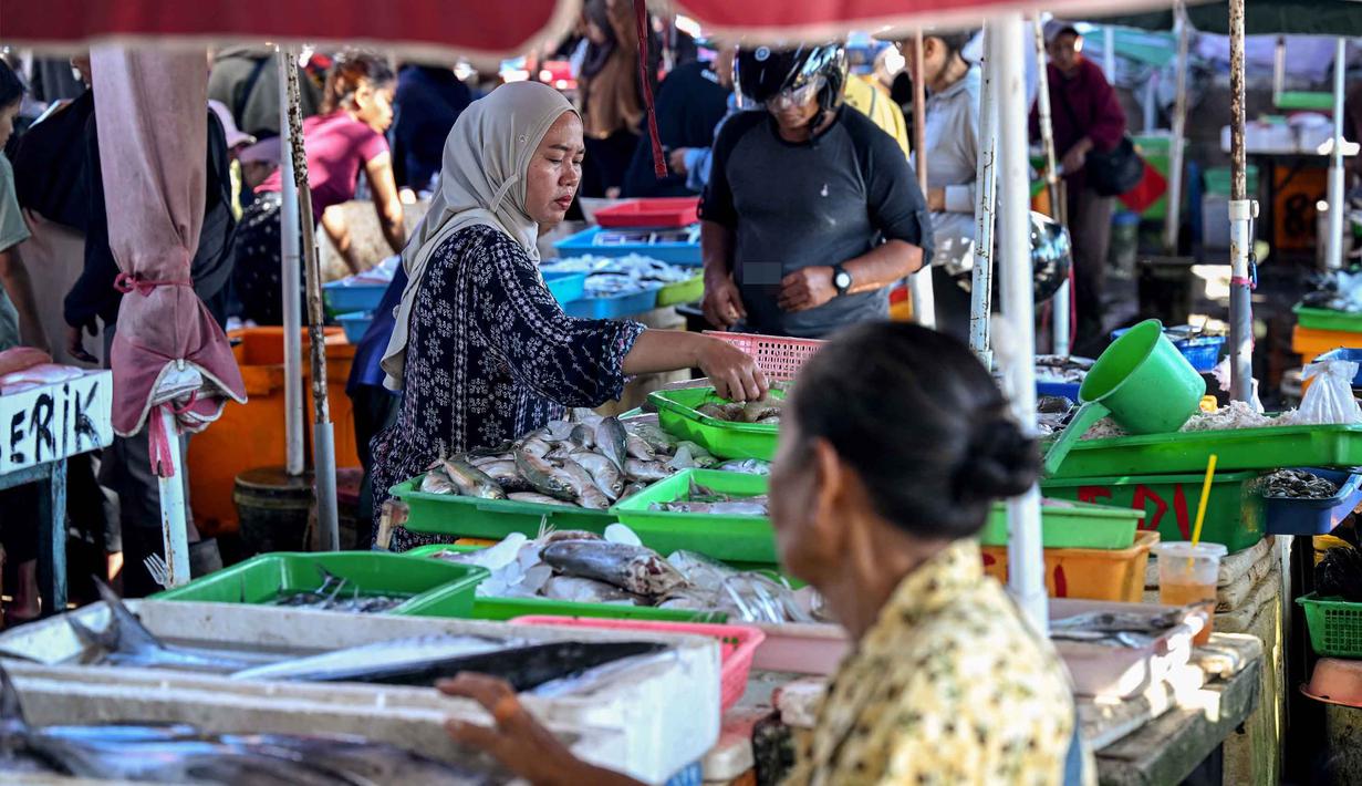 Diketahui, pada 2024, produksi perikanan di Bali didominasi hasil laut dengan total mencapai lebih dari 127 ribu ton, didominasi komoditas tuna dan cakalang. Tampak dalam foto, pedagang menjual ikan di pasar di pantai Kedonganan dekat Denpasar, Bali, pada Jumat 10 April 2026. (SONNY TUMBELAKA/AFP)