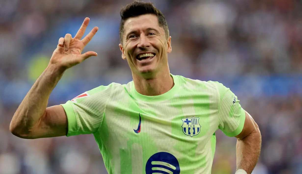 Penyerang Barcelona, Robert Lewandowski melakukan selebrasi setelah mencetak gol ketiganya pada pertandingan sepak bola Liga Spanyol melawan Deportivo Alaves di stadion Mendizorroza, Vitoria, Minggu 6 Oktober 2024. (Cesar Manso/AFP)
