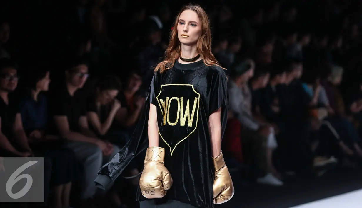 Seorang model mengenakan sarung tinju berpose diatas catwalk dalam Jakarta Fashion Week 2017 di Jakarta, Minggu (23/10). Desainer Oxcel yang mengidolakan Muhammad Ali, menampilkan karyanya dengan elemen-elemen tinju. (Liputan6.com/Faizal Fanani)