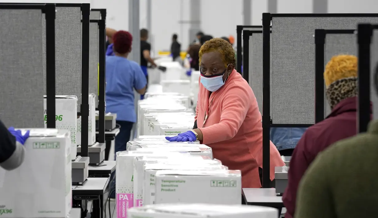 Aktivitas pekerja menyiapkan kardus berisi vaksin Moderna COVID-19 untuk pengiriman di pusat distribusi McKesson di Olive Branch, Mississippi, Minggu (20/12/2020). Pemerintah Amerika Serikat telah menyetujui vaksin Covid-19 Moderna sebagai vaksin kedua di negara itu. (AP Photo/Paul Sancya, Pool)
