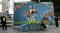 Warga berpose dengan logo Piala Eropa 2020 saat  peluncuran di London, Inggris, 21 September 2016. UEFA memundurkan jadwal Piala Eropa 2020 hingga tahun 2021. (AP Photo/Tim Ireland, File)