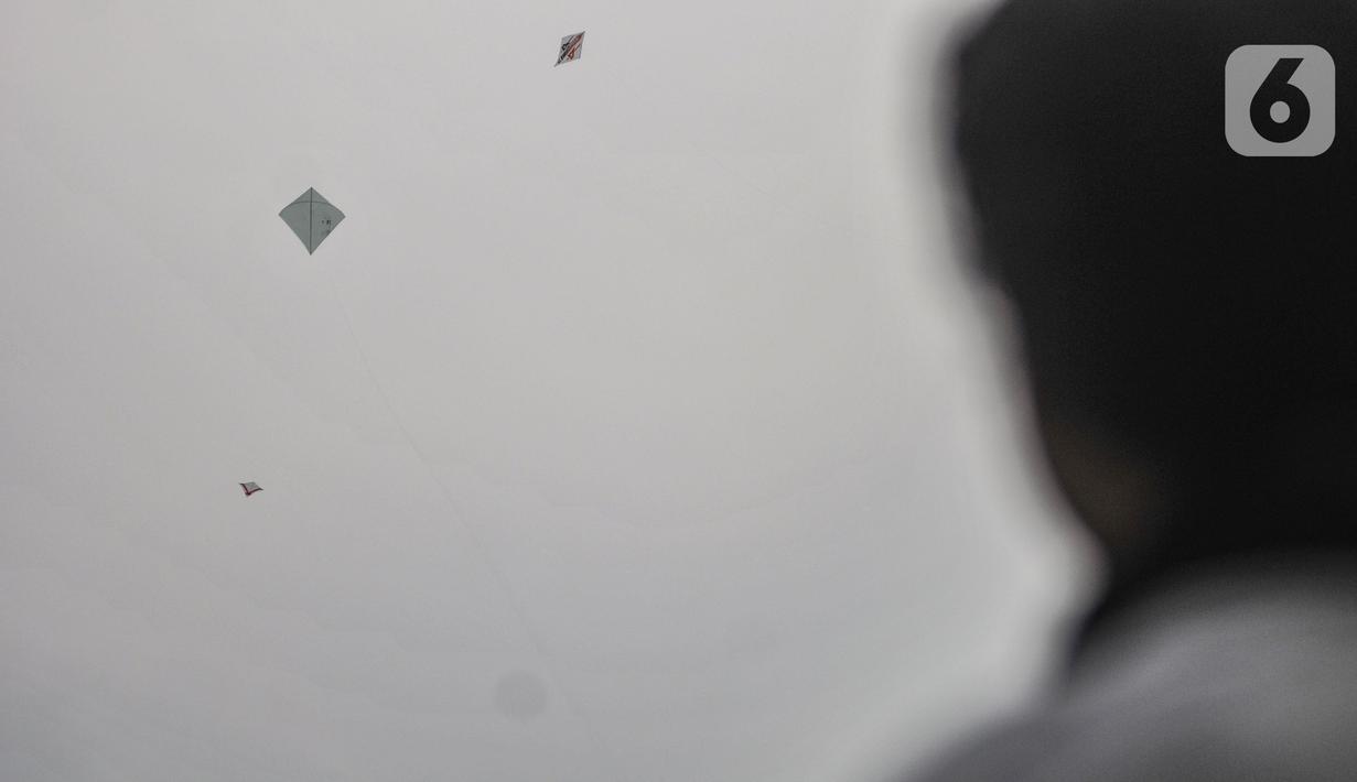 Warga bermain layang-layang di pinggir Kanal Banjir Timur (KBT), Duren Sawit, Jakarta, Senin (19/4/2021). KBT menjadi lokasi favorit warga untuk mengisi waktu menunggu buka puasa atau ngabuburit, salah satunya dengan bermain layang-layang bersama keluarga. (merdeka.com/Iqbal S Nugroho)