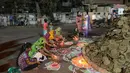 Warga bersiap di dekat Holika untuk melakukan ritual, Ahmedabad, India, Minggu (12/3). Bagi warga setempat Holika melambangkan kemenangan kebaikan atas kejahatan. (AFP PHOTO / SAM PANTHAKY)