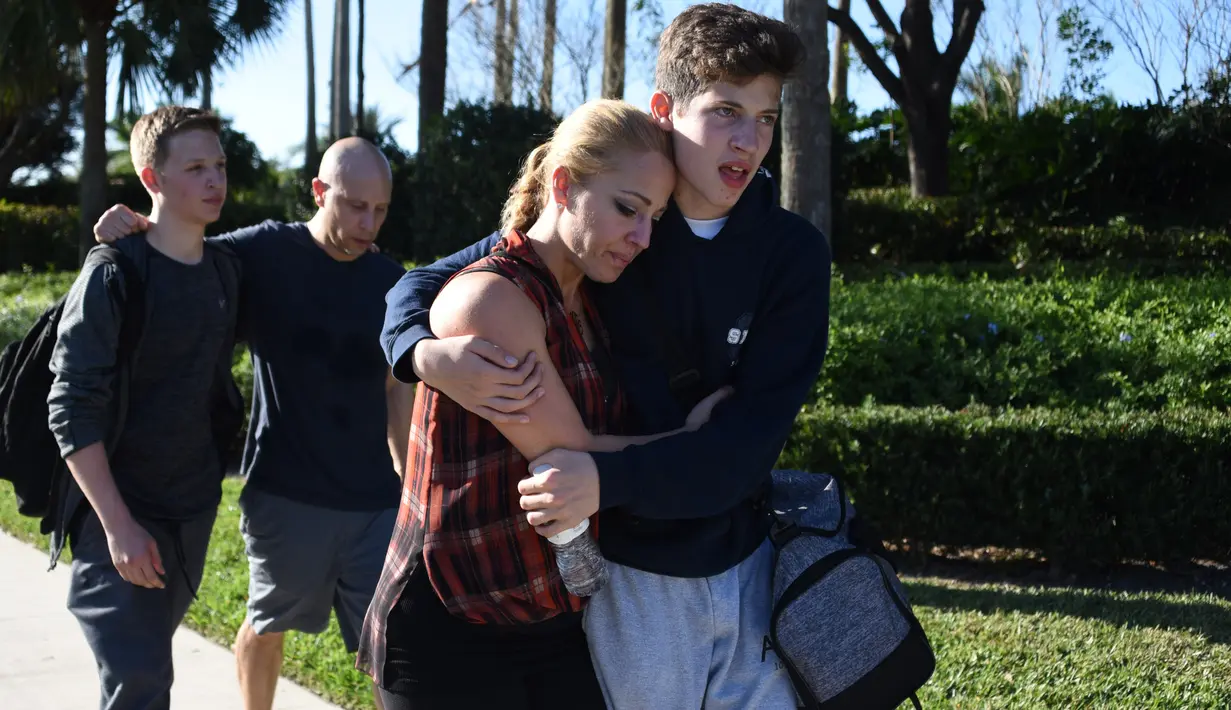 Siswa tampak terguncang setelah terjadi penembakan massal yang mengguncang sekolah menengah atas Marjory Stoneman Douglas di Parkland, Florida, Rabu (14/2). Pelaku penembakan menyerahkan diri tanpa perlawanan kepada polisi. (Michele Eve Sandberg/AFP)