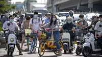 Para komuter yang mengenakan masker menunggu di persimpangan kawasan pusat bisnis di Beijing, China, Selasa (31/5/2022). Otoritas Shanghai mengatakan mereka akan mengambil beberapa langkah besar pada Rabu untuk membuka kembali kota terbesar di China setelah dua bulan penguncian COVID-19. (AP Photo/Mark Schiefelbein)