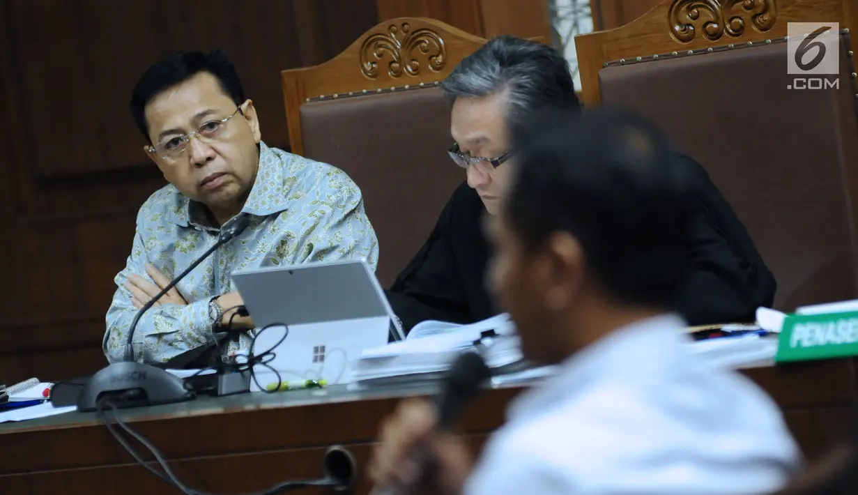 Terdakwa dugaan korupsi proyek e-KTP, Setya Novanto (kiri) menyimak keterangan saksi pada sidang lanjutan di Pengadilan Tipikor, Jakarta, Senin (12/3). Sidang mendengar keterangan saksi dan saksi ahli. (Liputan6.com/Helmi Fithriansyah)