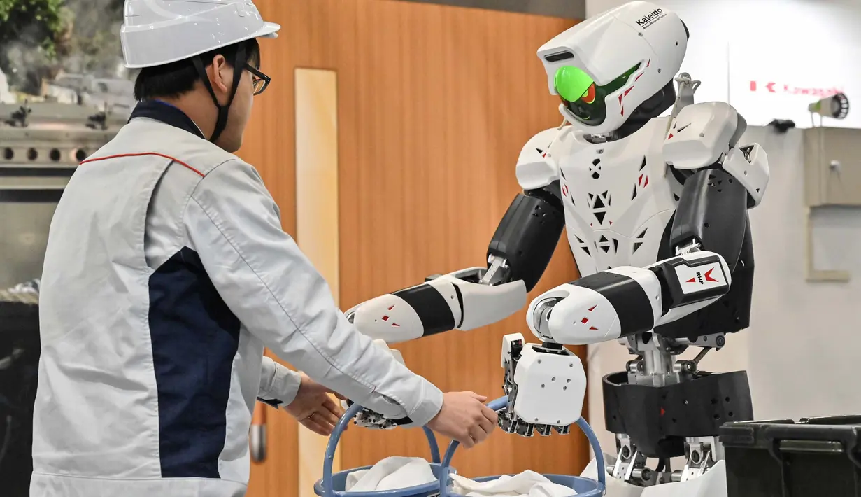 Robot menerima pemberian ember dari seorang karyawan. (Richard A. Brooks/AFP)
