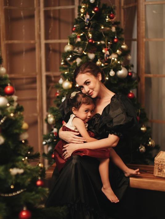 Rianti Cartwright juga tampil menawan dengan simpel dress berwarna hitam. Sedangkan sang putri tampak menggemaskan dengan dress putih dan merah dalam pangkuan sang ibu. (Liputan6.com/IG/@riantic)