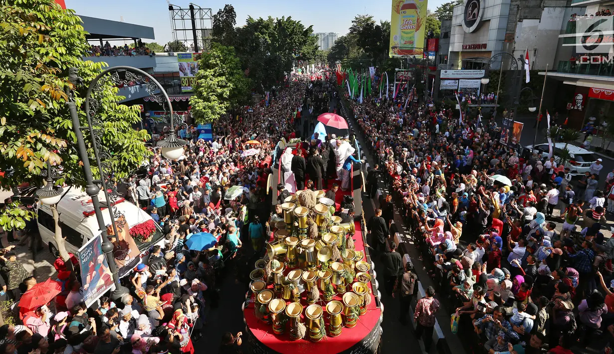 Ribuan warga berkumpul saat kendaraan hias yang ditumpangi Presiden Joko Widodo (Jokowi) dan Ibu Negara, Iriana Joko Widodo selama Karnaval Kemerdekaan Pesona Parahyangan 2017 melintas di pusat Kota Bandung, Sabtu (26/8). (Liputan6.com/Johan Tallo)