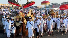 Prosesi sakral ini merupakan rangkaian menjelang Hari Raya Nyepi Tahun Baru Saka 1948 yang jatuh pada 19 Maret 2026. Tampak dalam foto, umat Hindu saat mengikuti upacara doa Melasti di salah satu pantai di Denpasar, Bali, pada Senin 16 Maret 2026. (SONNY TUMBELAKA/AFP)