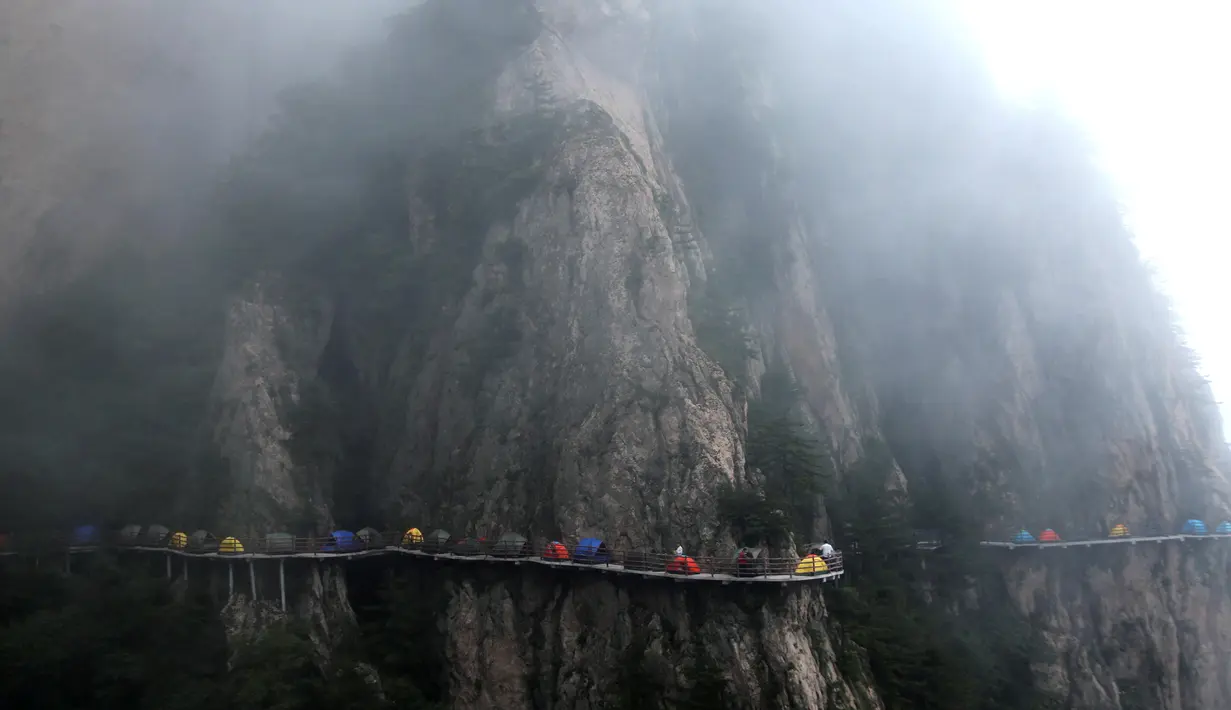 Kabut saat menyelimuti tenda-tenda yang didirikan backpacker di tebing Gunung Laojun, Louyang, Henan, China saat bac (16/7). Kamping bersama ini merupakan bagian dari acara Laojun Mountain Camp Festival. (REUTERS/Stringer)
