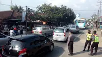 Sejumlah anggota kepolisian tengah mengamankan antrian kendaraan arus balik di dekat pospam Limbangan, Garut (Liputan6.com/Jayadi Supriadin)