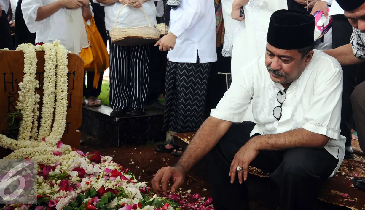 Gubernur Banten, Rano Karno menatap makam ibunya, Lily Soekarno M Noor usai pemakaman di TPU Tanah Kusir Jakarta, Senin (7/12/2015). Ibunda Rano Karno wafat di usia 77 tahun akibat komplikasi penyakit. (Liputan6.com/Helmi Fithriansyah)