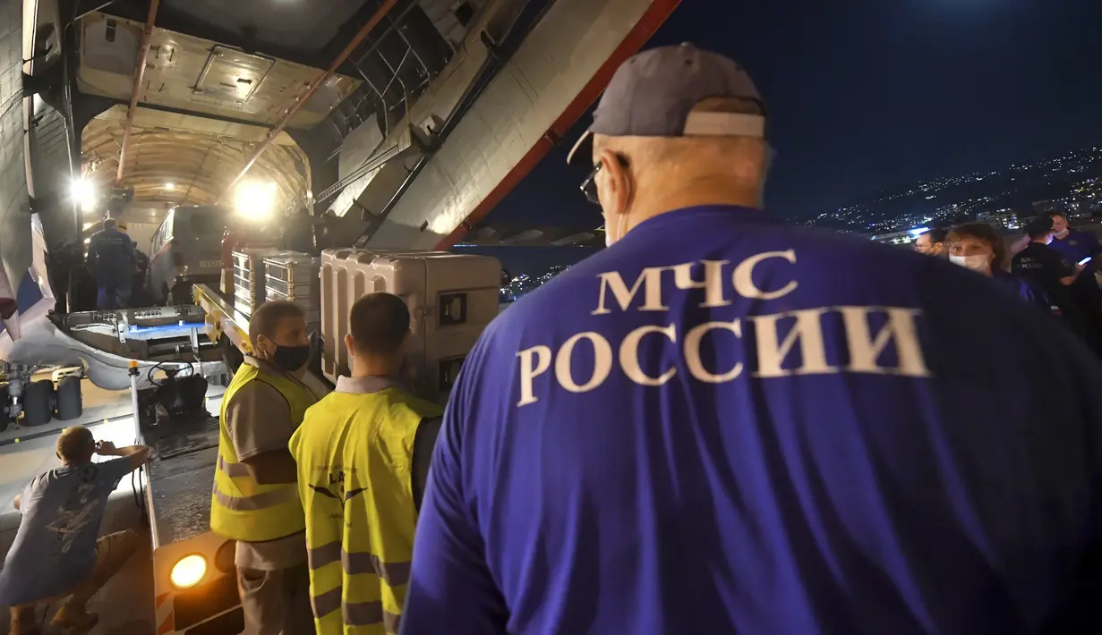 Para pekerja memuat kotak pasokan bantuan Rusia dari pesawat kargo Rusia ke truk di sebuah bandara di Beirut, Lebanon, Rabu (5/8/2020). Rusia mengirim lima paket bantuan ke Lebanon setelah ledakan besar di Pelabuhan Beirut. (AP Photo/Ministry of Emergency Situations press service via AP)