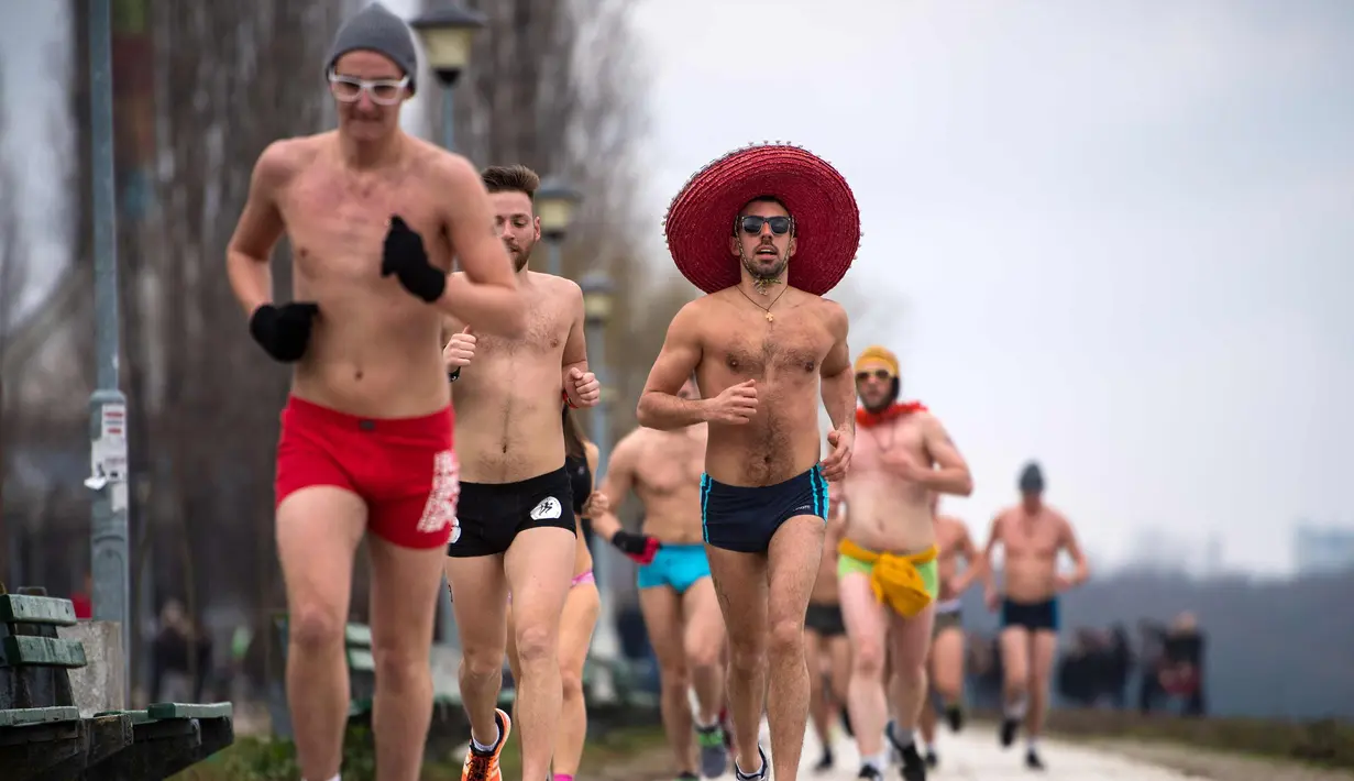 Peserta berlari saat mengikuti lomba Underpants Run di tepi sungai Danube di Beograd, Serbia (4/2). Dengan hanya mengenakan pakaian dalam para peserta tetap semangat mengikuti lomba dengan suhu mendekati nol derajat Celcius. (AFP Photo/Andrej Isakovic)