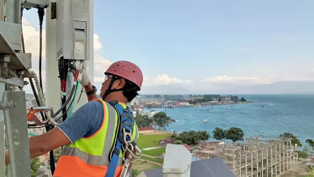 Petugas jaringan XL memeriksa menara BTS XL Axiata yang ada di Danau Toba, Parapat, Sumatera Utara