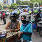 Petugas kepolisian lalu lintas mengecek SIM pengendara motor saat Operasi Zebra Jaya 2020 di kawasan Cawang, Jakarta, Senin (26/10/2020). Operasi Zebra Jaya dilaksanakan pada 26 Oktober-8 November 2020 untuk menekan jumlah pelanggaran lalu lintas. (Liputan6.com/Faizal Fanani)