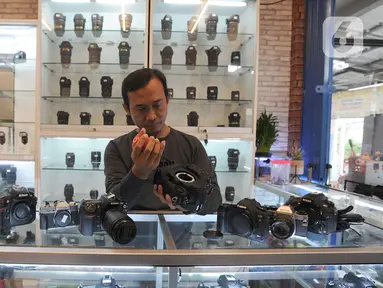 Pedagang membersihkan kamera bekas yang dijual belikan di CSZ Camera di Pondok jagung, Tangerang Selatan, Banten, Senin (20/12/2021). Di masa pandemi penjualan kamera bekas meningkat 30 persen. (merdeka.com/Arie Basuki)