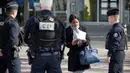 Polisi memeriksa dokumen seorang wanita saat lockdown di Place d'Italie, Paris, Prancis, Rabu (18/3/2020). Prancis memberlakukan lockdown selama 15 hari ke depan mulai 17 Maret 2020. (Thomas SAMSON/AFP)