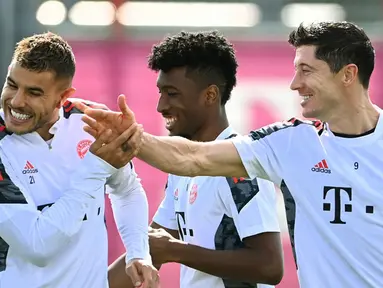 (kiri/kanan ) Pemain Bayern Munchen Lucas Hernandez, Kingsley Coman, dan Robert Lewandowski bercanda saat sesi latihan di tempat latihan klub di Munchen, Jerman, 13 September 2021. Bayern Munchen akan menghadapi Barcelona pada pertandingan Grup E Liga Champions. (CHRISTOF STACHE/AFP)