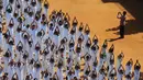 Seseorang mengabadikan momen saat Ribuan pelajar India melakukan senam yoga di Chennai, India, Senin (20/6). Kegiatan ini untuk memeriahkan perayaan Hari Yoga Internasional. (AFP PHOTO/ Arun Sankar)