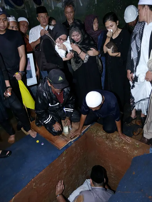 Tangis dari keluarga kembali pecah ketika almarhum hendak dimasukkan ke liang lahat. Isak tangis dari keluarga terus terdengar. Begitu juga lantunan doa turut mengiringi hingga jenasah tertutup tanah merah. (Bambang E. Ros/Bintang.com)