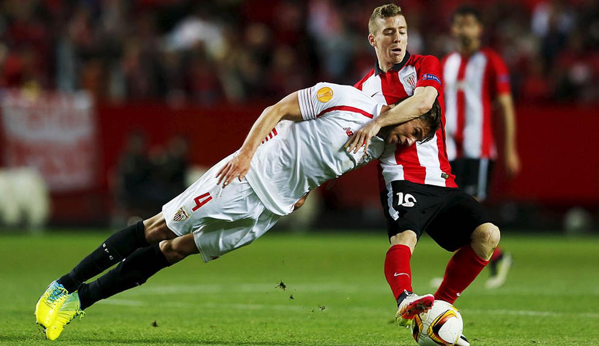 1. Bek Sevilla, Grzegorz Krychowiak, berebut bola dengan striker Athletic Bilbao, Iker Muniain, pada laga Liga Europa di Stadion Ramon Sanchez Pizjuan, Spanyol, Kamis (14/4/2016). Sevilla lolos ke semifinal melalui adu penalti. (Reuters/Marcelo Del Pozo)