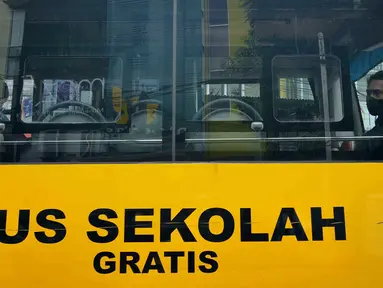 Sejumlah pasien COVID-19 berada dalam bus sekolah yang akan mengantarkan mereka menuju RSDC Wisma Atlet di Puskesmas Kecamatan Tebet, Jakarta, Kamis (3/2/2022). Satgas Penanganan COVID-19 mencatat kenaikan kasus positif COVID-19 dalam satu pekan terakhir. (Liputan6.com/Herman Zakharia)