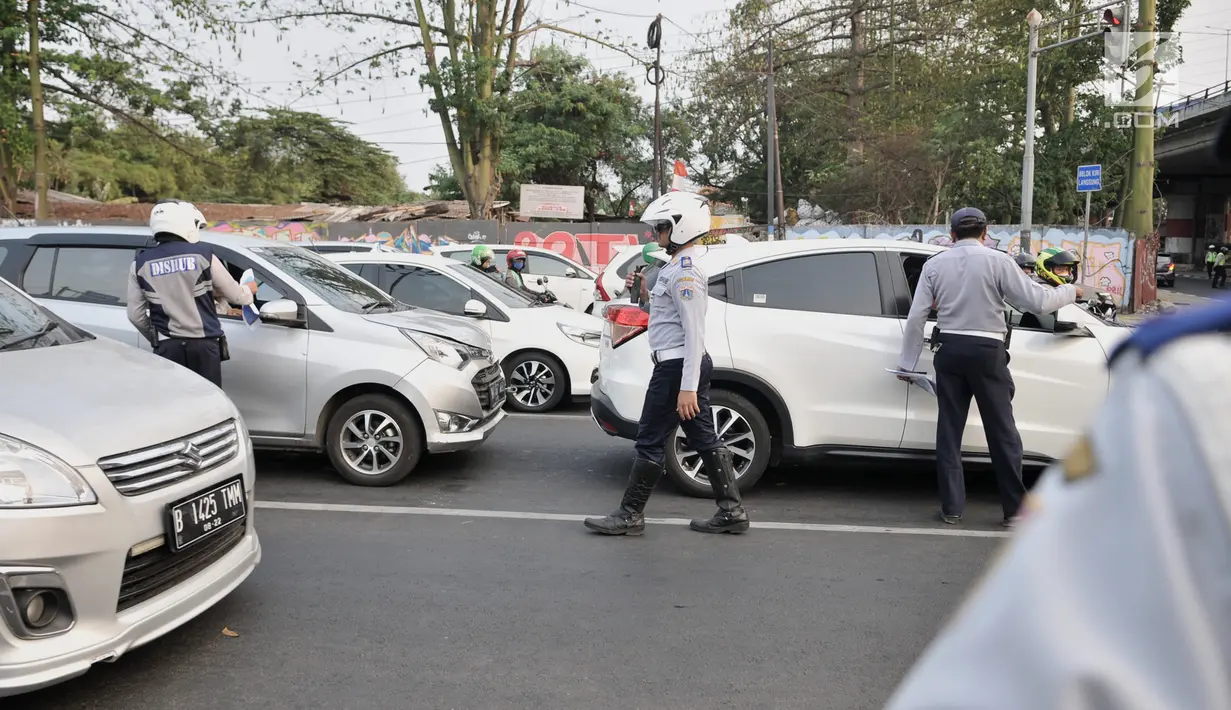 Petugas Dinas Perhubungan DKI Jakarta melakukan sosialisasi uji coba perluasan sistem ganjil genap kepada pengendara di kawasan Pramuka, Jakarta, Senin (12/8/2019). Pemberlakuan dan penegakan hukum terkait perluasan sistem ganjil genap dilakukan pada 9 September 2019. (merdeka.com/Iqbal Nugroho)