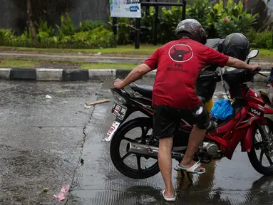 Pengendara berusaha menyalakan kendaraannya yang mogok akibat melintasi air banjir di jalan Gunung, Jakarta, Selasa (21/2). Hujan deras sejak malam tadi, membuat sejumlah wilayah Jakarta tergenang air banjir. (Liputan6.com/Faizal Fanani)