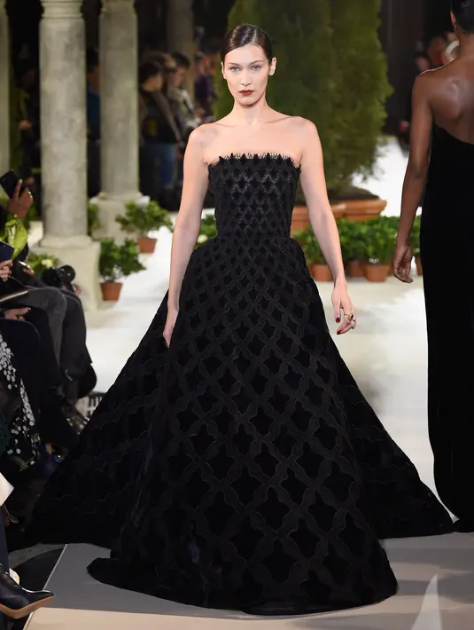 Model Bella Hadid berjalan di atas catwalk mengenakan koleksi terbaru dari Oscar de la Renta dalam New York Fashion Week, AS (12/2). Bella Hadid tampil cantik dengan gaun hitam panjang tanpa lengan. (AFP Photo/Slaven Vlasic)