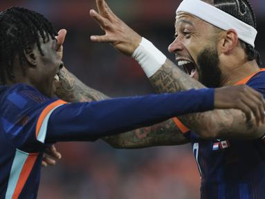 Penyerang Belanda Memphis Depay berselebrasi dengan Jeremie Frimpong setelah mencetak gol pertama timnya ke gawang Kanada pada laga uji coba menjelang EURO 2024 di De Kuip, Feyenoord, Jumat (7/6/2024) dini hari WIB. (AP Photo/Patrick Post)