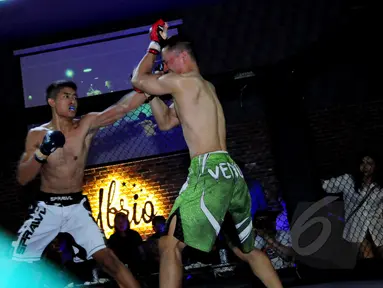  Salah satu atlet melakukan pukulan kepada lawannya pada ajang XXC Championship 2015 yang dihelat di Embrio Markas Cafe, Jakarta, Minggu (12/04/15). Kejuaraan memperebutkan gelar Indonesia Extreme Cage Champtionship 2015. (Liputan6.com/Faisal R Syam)