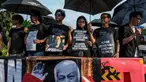 Para aktivis memegang payung hitam dan poster selama Aksi Kamisan di depan Istana Kepresidenan, Jakarta, Kamis 30 April 2026. Hari ini, Kamis 30 April 2026, Aksi Kamisan ke-906 dilaksanakan seperti biasa. (BAY ISMOYO/AFP)